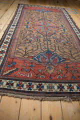 Vintage Kurdish Hamadan rug showing geometric tree of life motifs in camel, red, and blue.