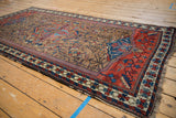 Vintage Hamadan rug's fringed end shows geometric madder red field and floral border.