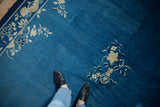 Cobalt blue Peking carpet field with ivory blossoms in a vase and floral vinery border.