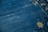 Vintage Chinese Peking carpet close-up: cobalt blue field, worn pile, and ivory floral border.