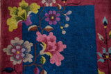 Nichols Art Deco rug detail, indigo blue field with pink, green blossoms and small white knots.