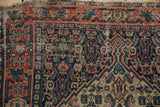 Antique Senneh rug corner, hand-knotted finned border and Herati field with visible wear.