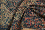 Antique Senneh rug detail: navy, red geometric Herati field, finned floral border, and aged pile.