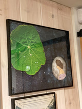 Angled view of framed Mother Moon art with a dark starry background and green leaf.