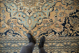 Detail of vintage Doroksh carpet: gold, dusty blue floral vines with even wear, faint foundation.