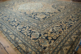 Navy blue and gold meandering vines and scrolling blossoms border on a vintage Doroksh carpet.