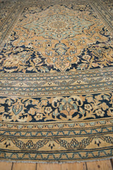 Secured end of the vintage Doroksh rug, with gold, navy, and blue floral border.
