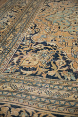 Intricate border and scrolling blossoms on this vintage Doroksh rug's aged gold and navy pile.