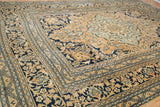 Softened gold, navy, and dusty blue meandering floral motifs on vintage Doroksh carpet.