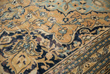 Vintage Doroksh carpet section with gold ground, navy scrolling vines, and worn dusty blue accents.