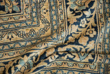 Gold, navy, dusty blue scrolling blossom motifs on a vintage Doroksh carpet.