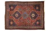 Vintage Persian Qashqai carpet with triple navy medallions on a madder root red field of motifs.