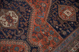 Vintage Qashqai rug featuring angular hook-and-latch design in madder, navy, and ivory tones.