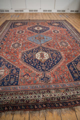 Multi-banded border of vintage Qashqai carpet, navy, red, ivory patterns and natural fringe.