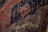 Richly colored, textured fold of the vintage Qashqai carpet, featuring intricate hook-and-latch motifs.