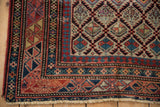 Corner of antique Daghestan rug, showcasing geometric motifs, patterned borders, and aged pile.