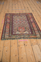 Primitive geometric border of antique Daghestan rug, showcasing colorful serpent motifs and fringe.