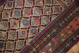 Geometric field and primitive serpent border motifs on antique Daghestan rug with aged pile.