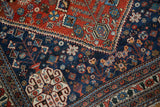 Serrated outline separating the red field and blue border on a fine vintage Abadeh rug corner.