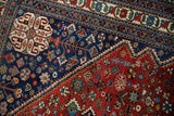Detail of the serrated outline between the red field and navy corner of a vintage Abadeh rug.