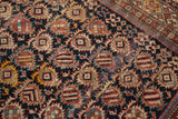 Navy, rust, celadon geometric botehs and pawn motif border on aged Caucasian rug.