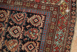 Antique Caucasian rug detail highlighting geometric crab border and worn areas with visible foundation.