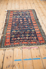 Antique Caucasian rug with geometric blossoms, pomegranates, and vibrant ribboned borders.