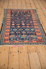 Geometric serpents and pomegranates on abrashed cobalt field, with brick red floral border.