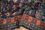 Antique Caucasian rug detail showing brick red floral main border, blue ribboned minor border, and field serpents.