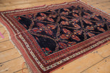Angled perspective of an antique Afshar rug's intricate lattice design on a navy field.