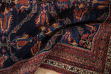 Close-up of an antique Afshar rug revealing its hand-knotted structure and rich navy and red dyes.