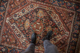 Vintage Kamseh rug: chestnut, navy, ivory pinwheel motifs and dragon-inspired border.