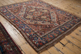 Vintage Kamseh rug close-up: navy blue dragon-style border with intricate red, ivory patterns.
