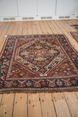 Hand knotted Persian Kamseh rug corner with stylized dragon motifs in navy and chestnut.