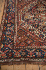 Vintage Kamseh rug corner, geometric border patterns in navy, chestnut, and ivory colors.