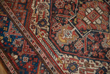 Close-up of Kamseh rug, featuring dragon style border, serpent motif, with navy, red, ivory tones.