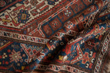 Textured detail of the vintage Kamseh rug showcasing geometric motifs in chestnut, indigo, and ivory.
