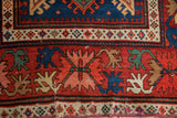 Close-up of the colorful crab-style palmette and blossom border on an antique Caucasian runner.