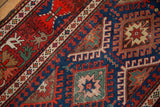 Close-up of a starburst gul and hook-and-latch motif on an antique Caucasian rug runner.