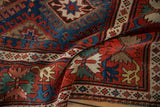 Close view of an antique Caucasian runner's geometric starburst and crab palmette motifs.