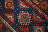 The hand-knotted structure of an antique Caucasian rug, showing a starburst gul and even wear.