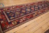 Long perspective of a late 19th-century Caucasian runner with geometric guls and vibrant red borders.