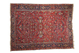 Vintage Gorevan carpet with cherry red field, allover germinating floral motifs and navy borders.