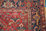 Gorevan rug corner, cherry red field, navy border, intricate floral motifs, and even wear.