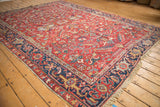 Vintage Gorevan carpet corner: cherry red floral field, navy border, even pile wear.
