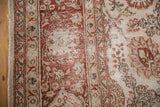 Distressed floral border and intact side cord of a vintage Persian Meshed carpet.