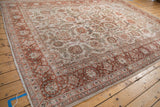Angled perspective of a vintage distressed carpet showing its time-softened texture and floral pattern.