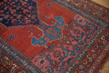Close-up on the dusty pink corner spandrel and border with stylized Herati designs on a vintage rug.