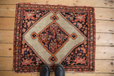 A finely woven antique Malayer showing its central diamond medallion, bird motifs in the spandrels, and frayed edges.