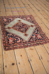 Angled perspective of an antique square Malayer rug, highlighting its geometric medallion and floral details.